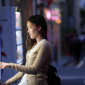Woman using Qiba product in vending machine